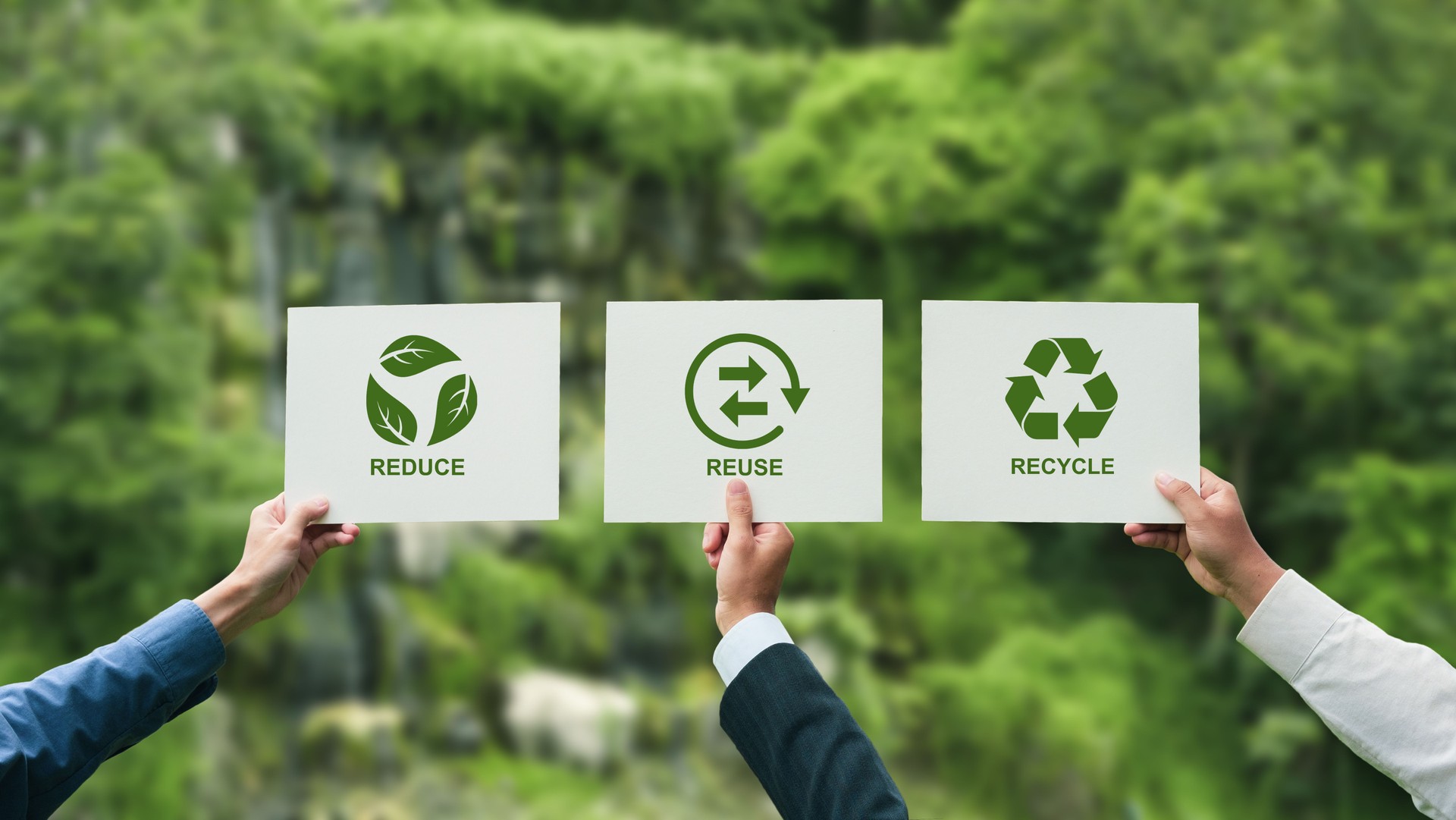 Businessman's hand holding paper with symbols of reduce, reuse and recycle. Environmental concept. World Environment Day. Reduce, reuse, recycle with green nature background.